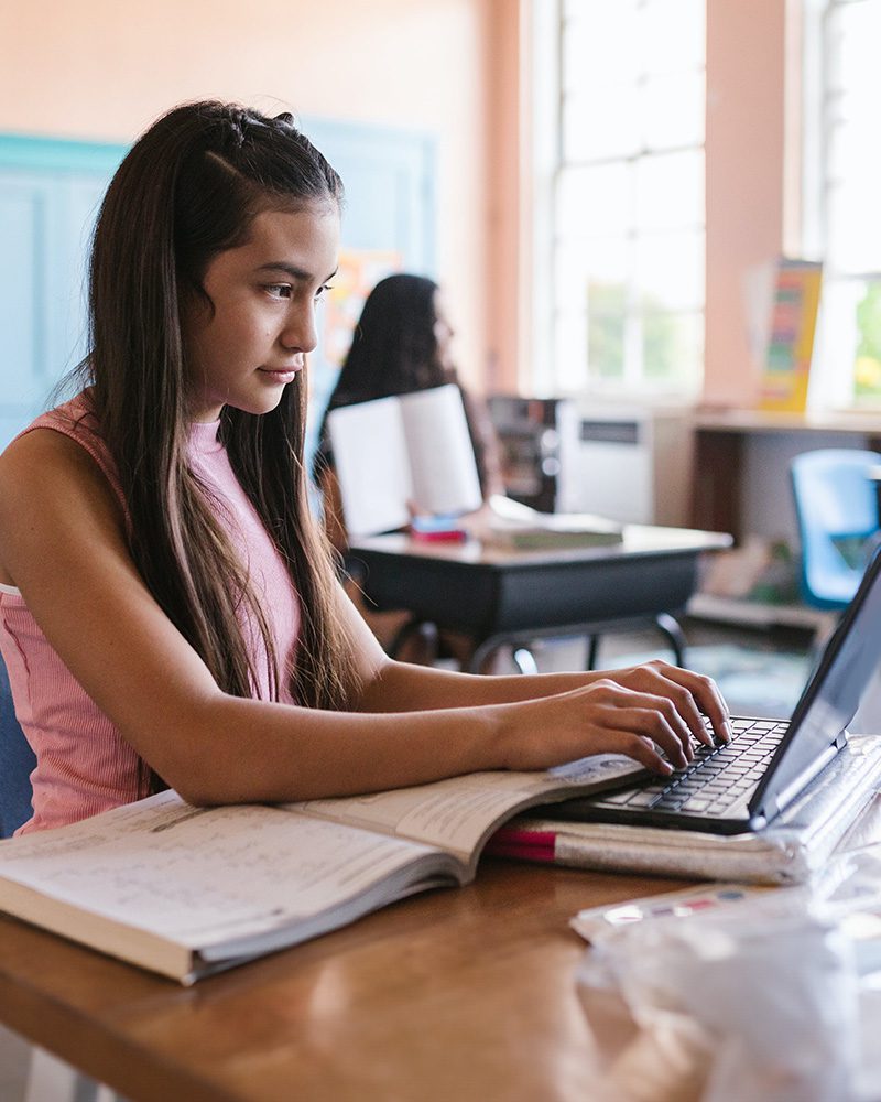 Young female student working on a laptop in class